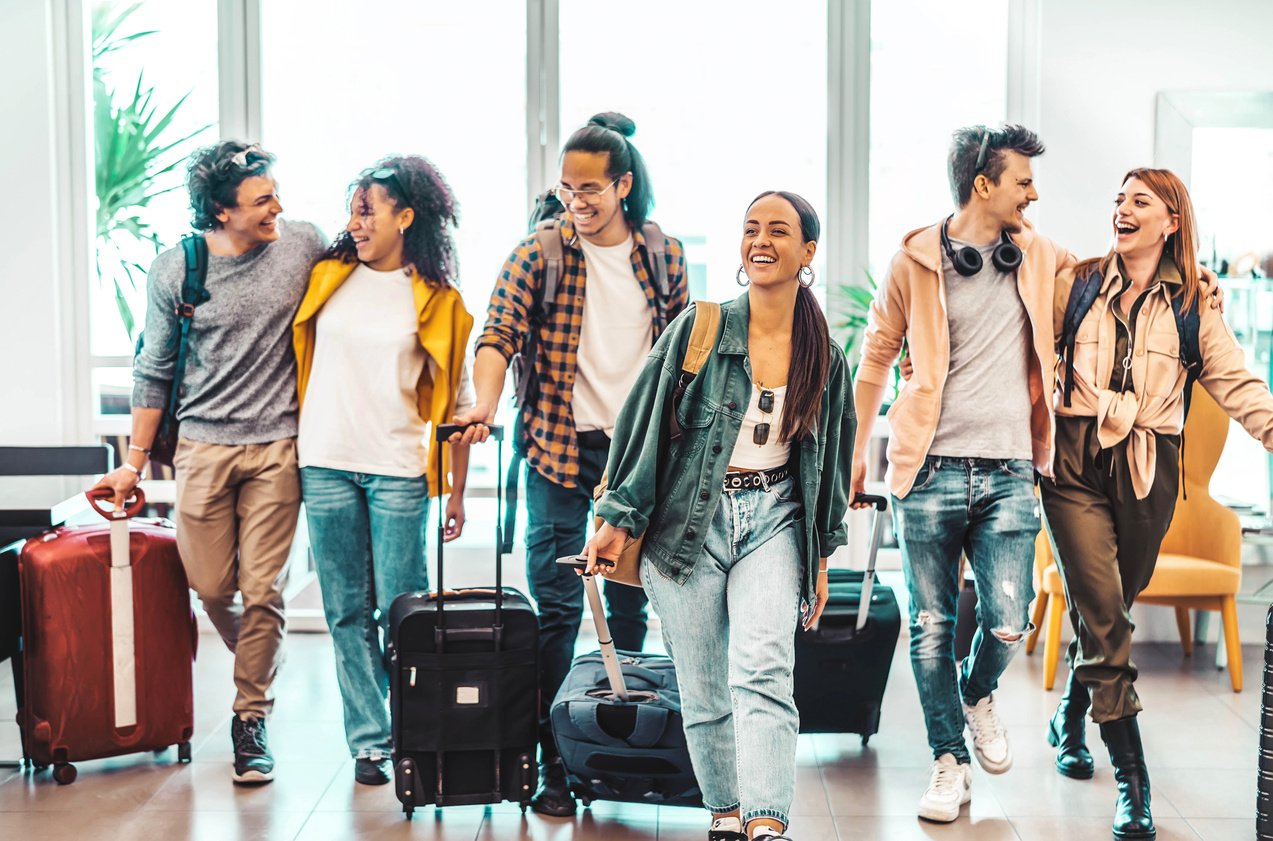 Young group of tourists with suitcases arriving at youth hostel